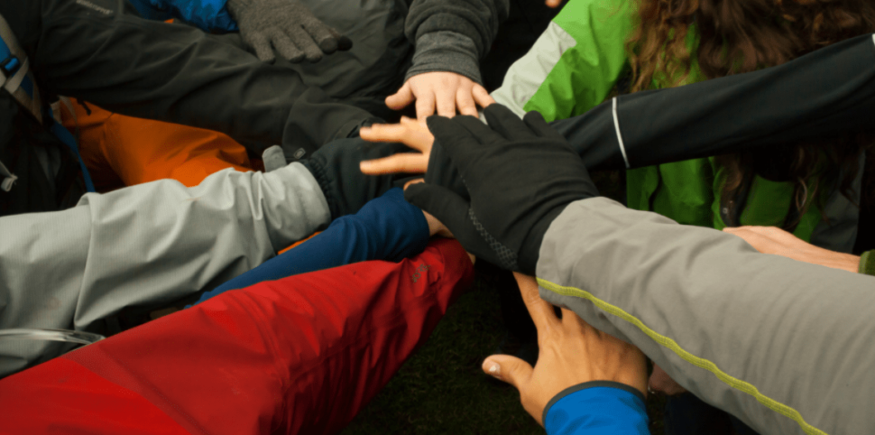 Hands put together in group huddle